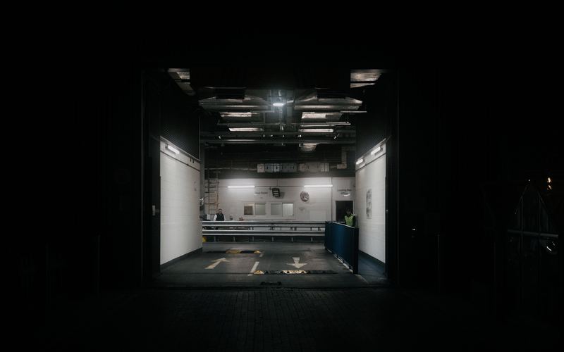 Entrada iluminada de uma área de carga e descarga, no meio do escuro